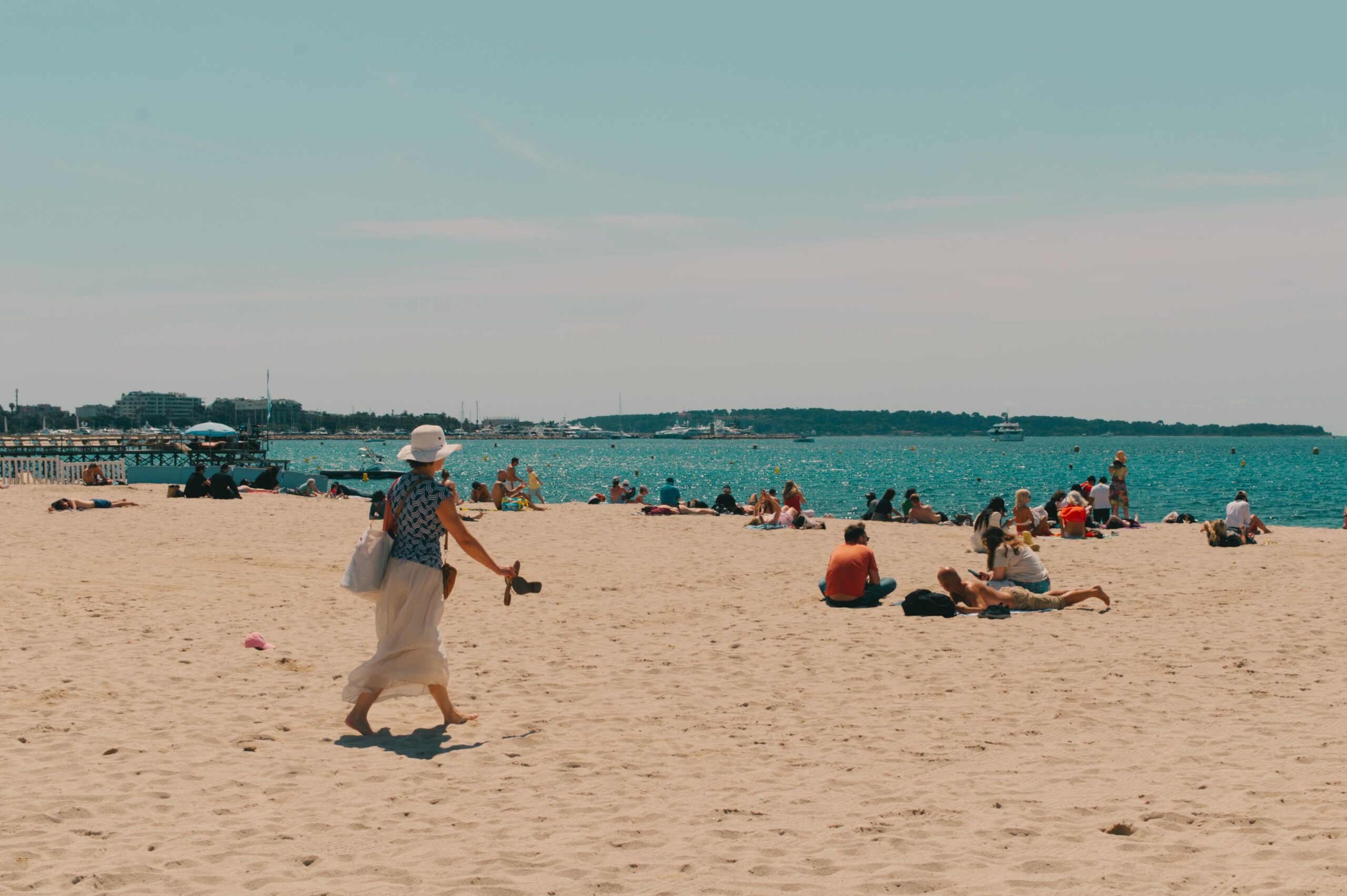 Menschen genießen einen sonnigen Tag an einem wunderschönen Sandstrand in Cannes, Frankreich.