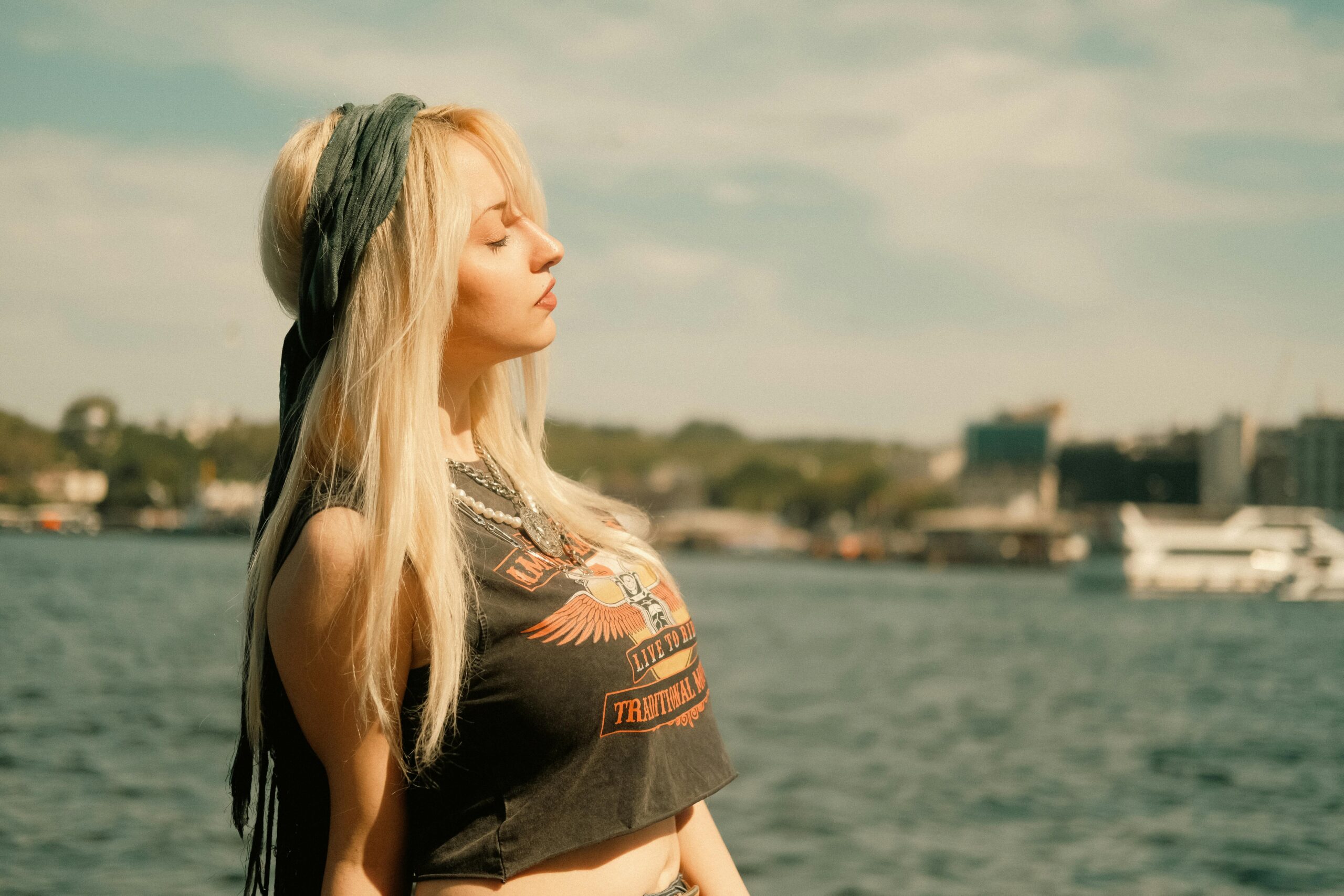 Ein ruhiger Moment am Wasser mit einer Frau, die draußen die Sonne genießt.