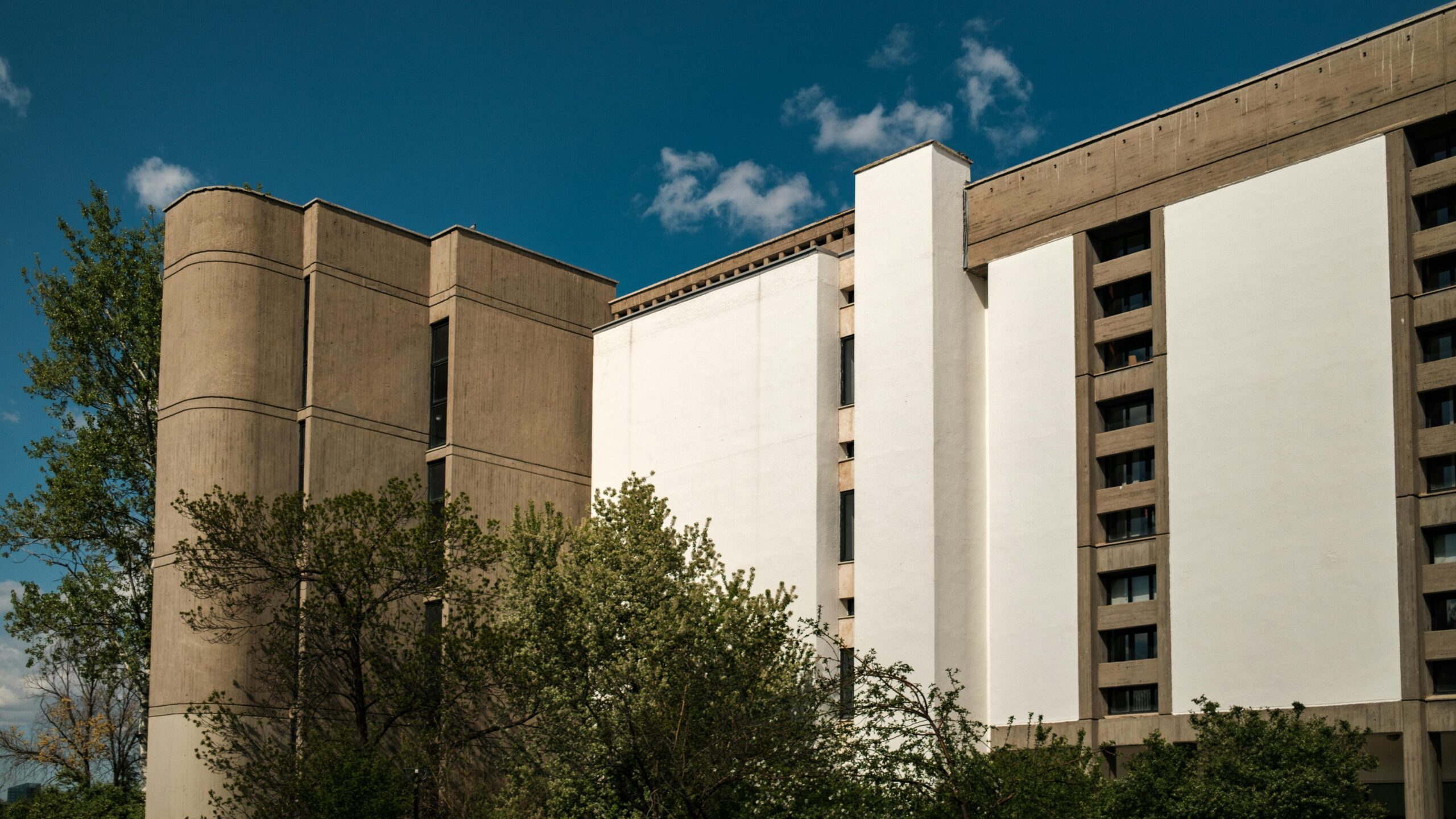 Außenansicht eines modernen Gebäudes mit Bäumen in Ankara, Türkei, unter einem klaren blauen Himmel.
