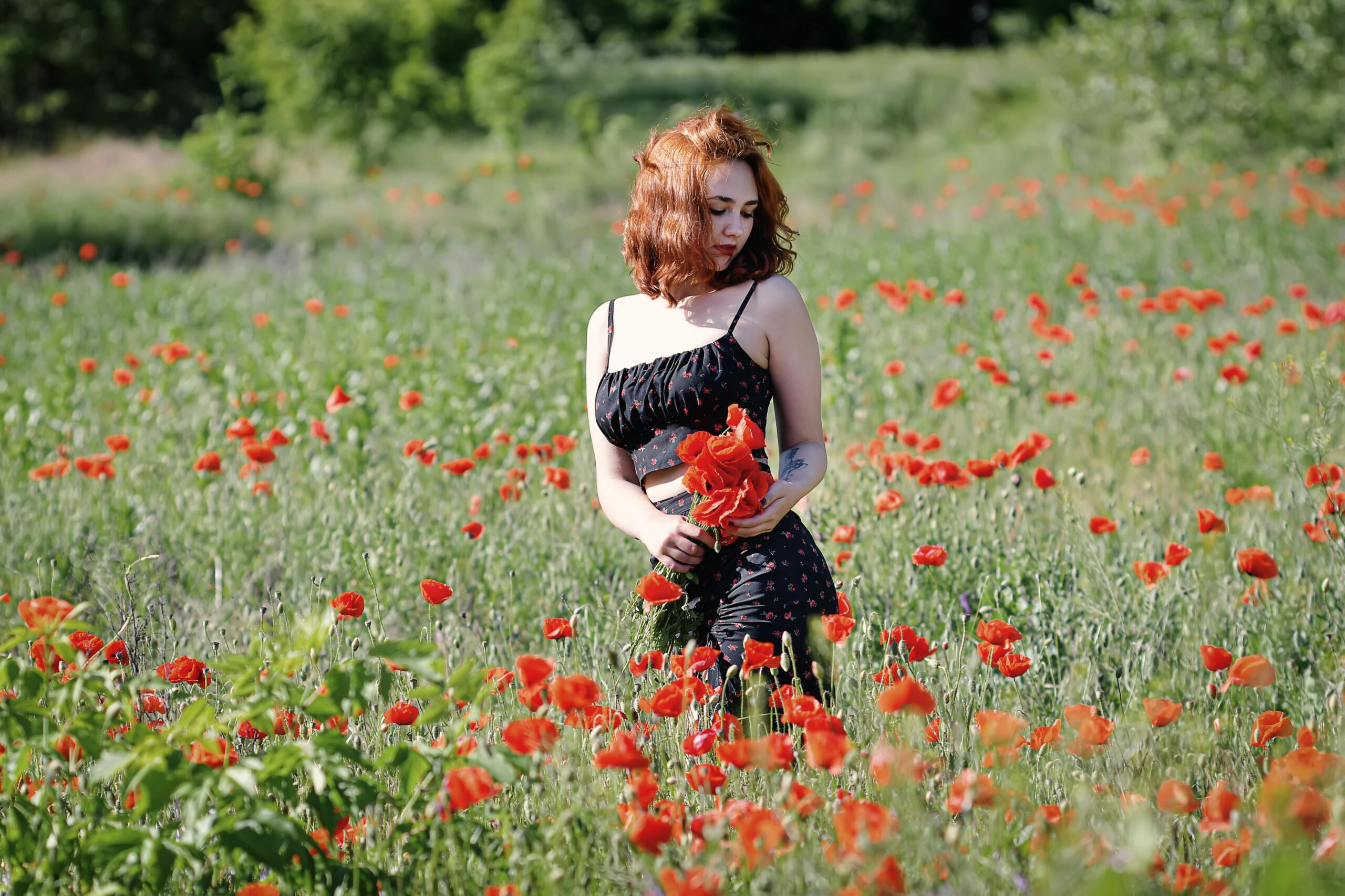Eine junge Frau genießt einen sonnigen Tag im Freien in einem leuchtenden Mohnfeld.