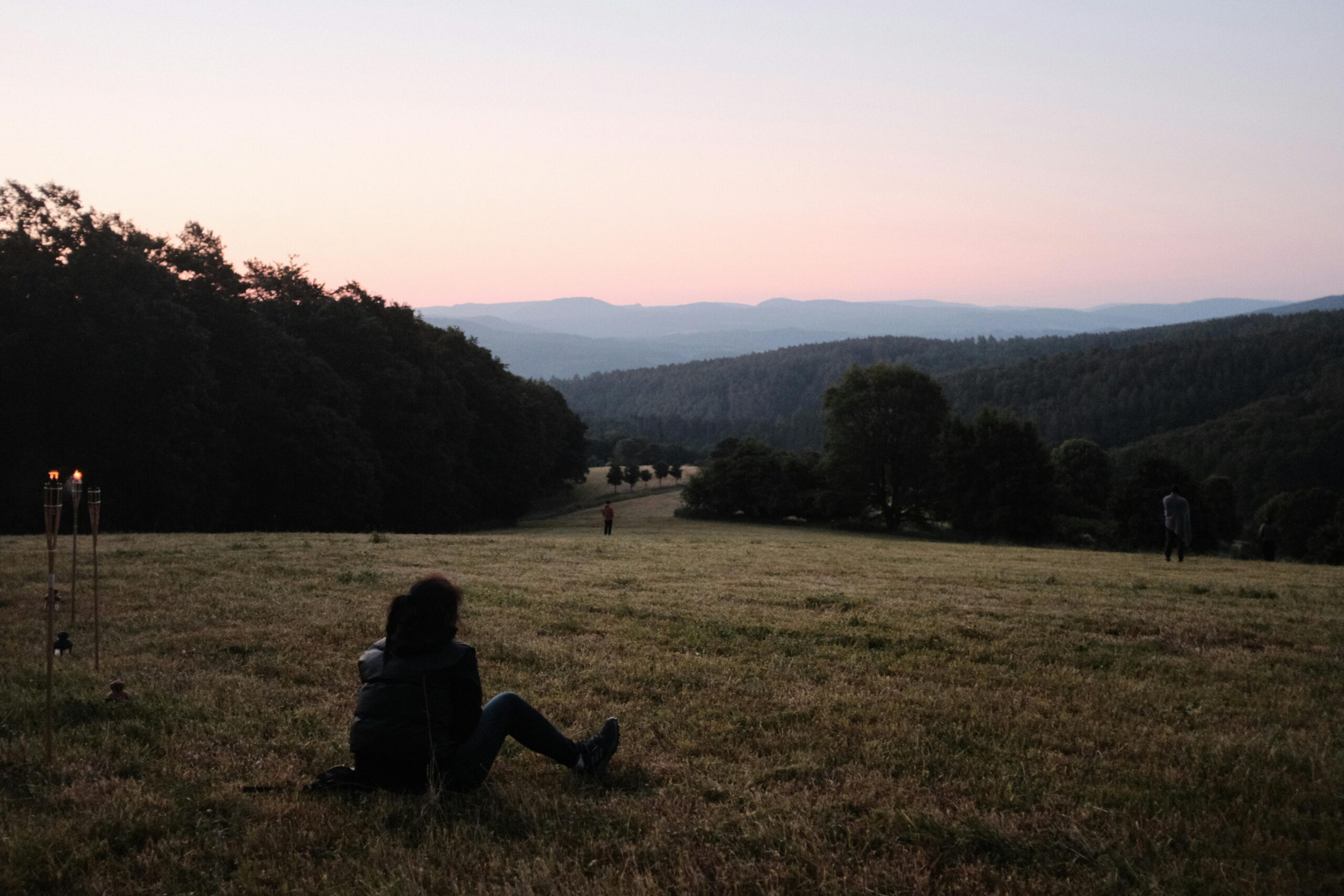 Friedliche Szene einer Person, die bei Sonnenuntergang auf einer Wiese in Schmalkalden, Thüringen, Deutschland entspannt.