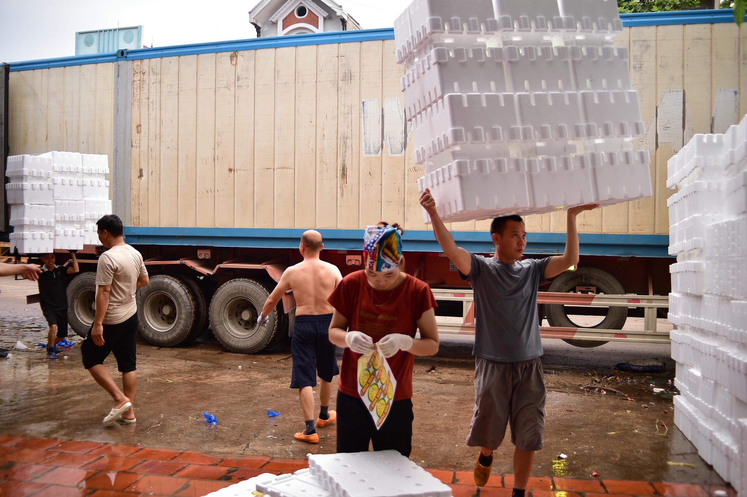 Arbeiter laden in Bac Giang, Vietnam, Styroporboxen auf einen LKW und stellen damit Teamarbeit unter Beweis.