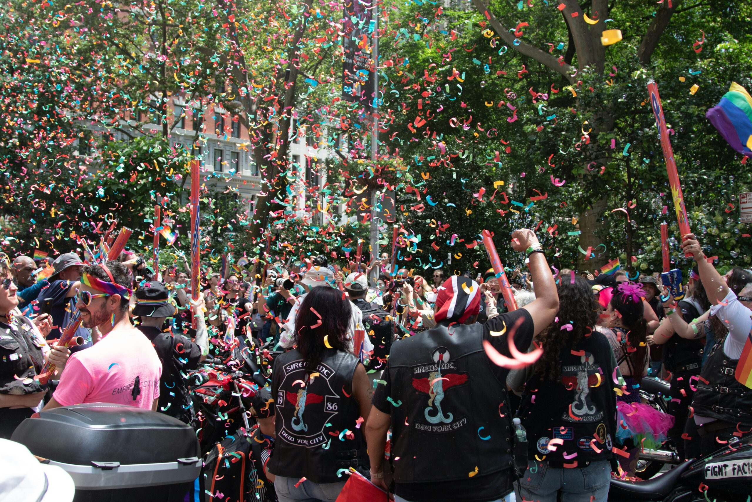 Aufregende Straßenparade in NYC mit buntem Konfetti und einer bunt gemischten Menge, die den Pride feiert.