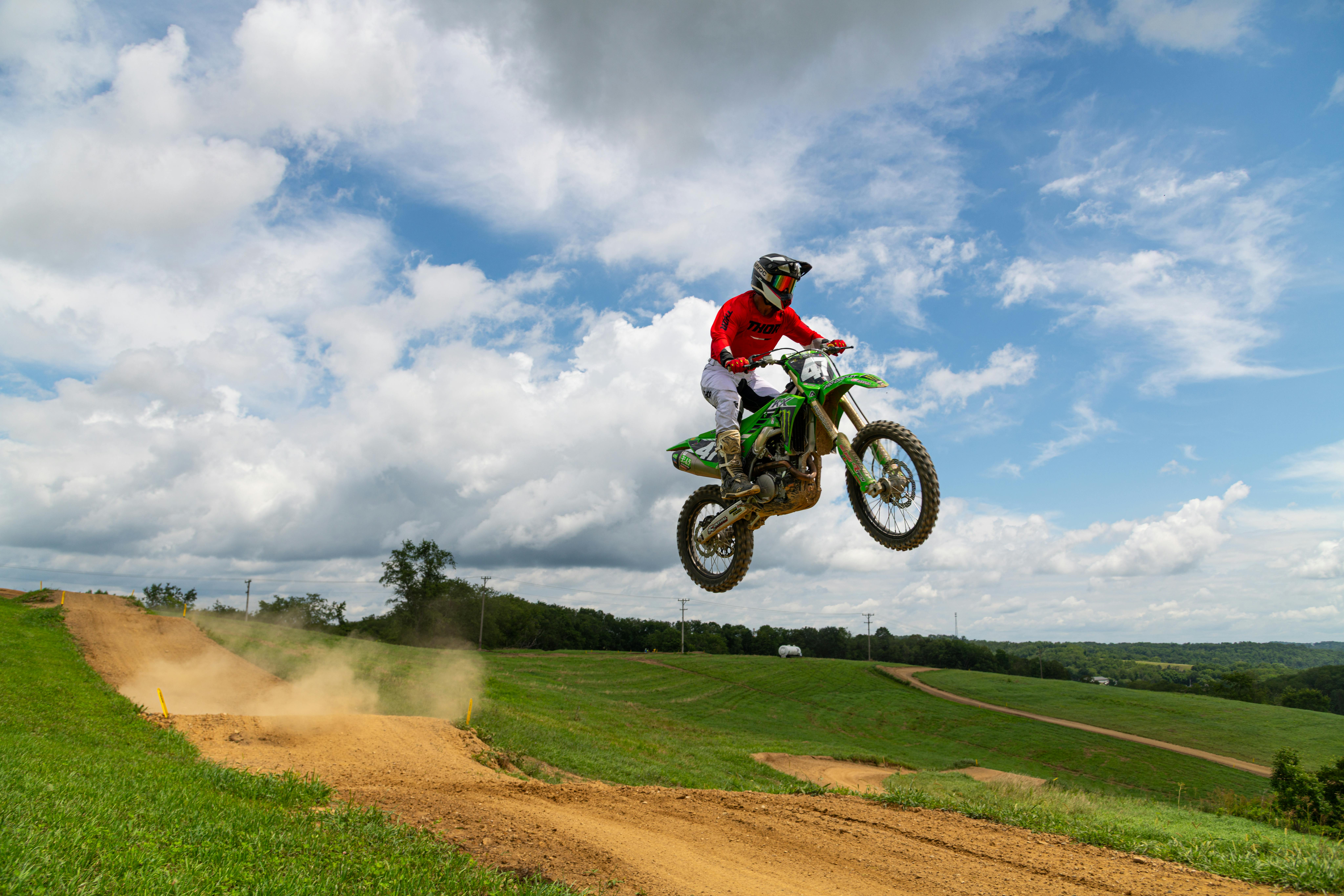 Spannender Dirtbike-Sprung auf einer unbefestigten Strecke in Pennsylvania unter klarem, sonnigem Himmel. Perfekt für Abenteuer- und Sportthemen.