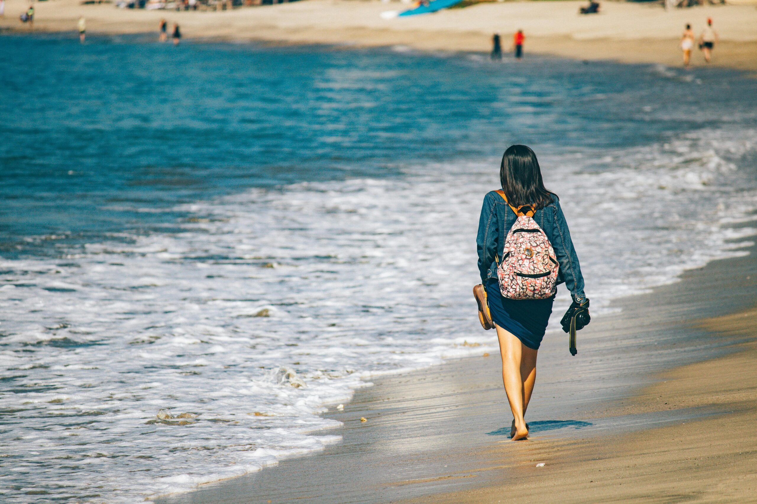 Frau Schlendert Mit Rucksack Und Kamera Am Sonnenstrand