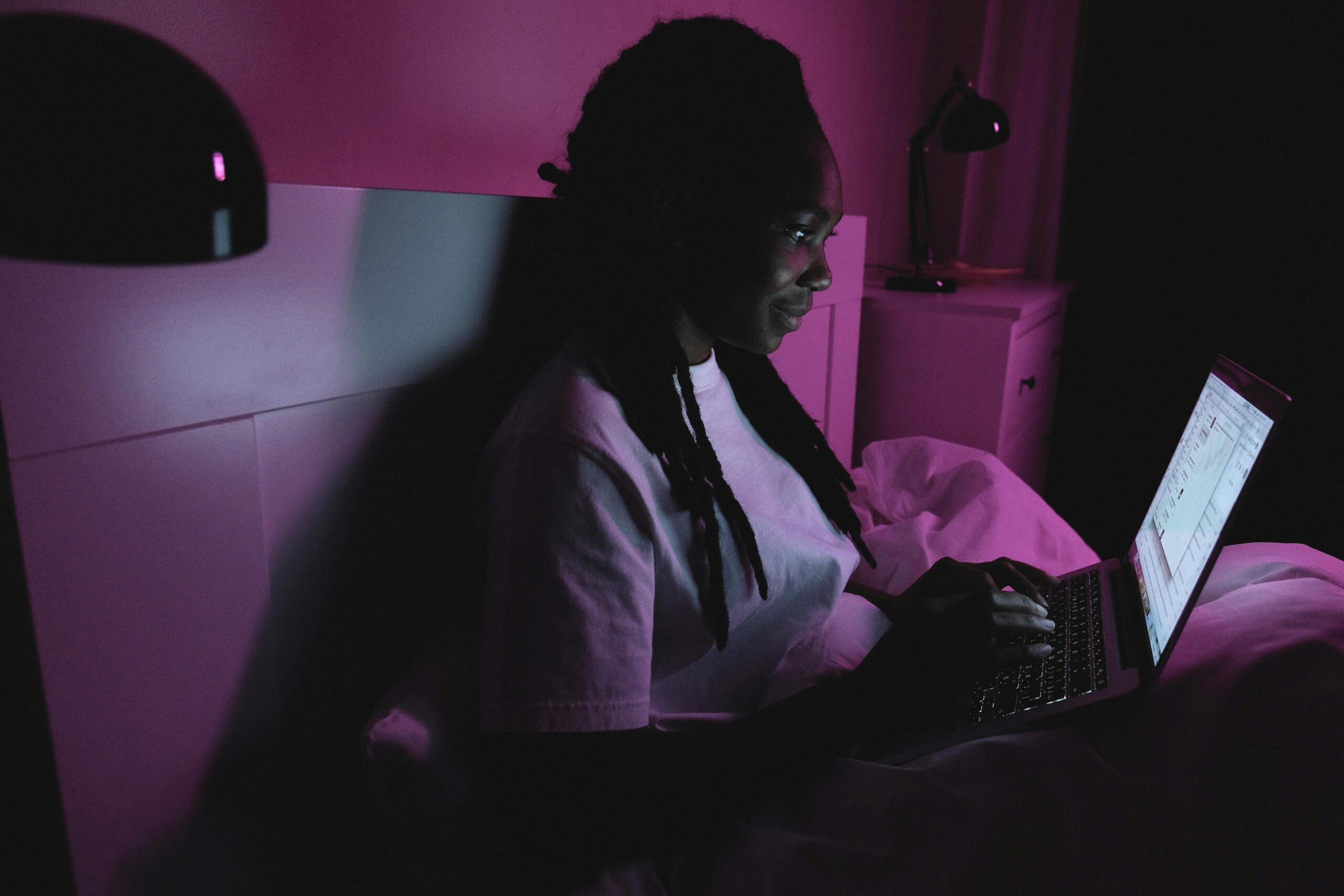Kostenloses Stock Foto zu afroamerikaner-frau, bett, bildschirm