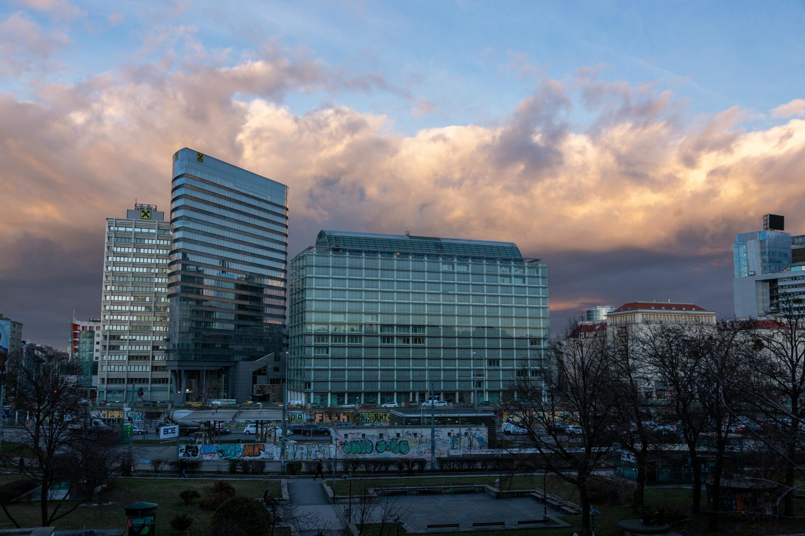 Stadtbild mit hohen Gebäuden unter dramatischen Wolken in der Abenddämmerung, das die urbane Architektur zur Schau stellt.
