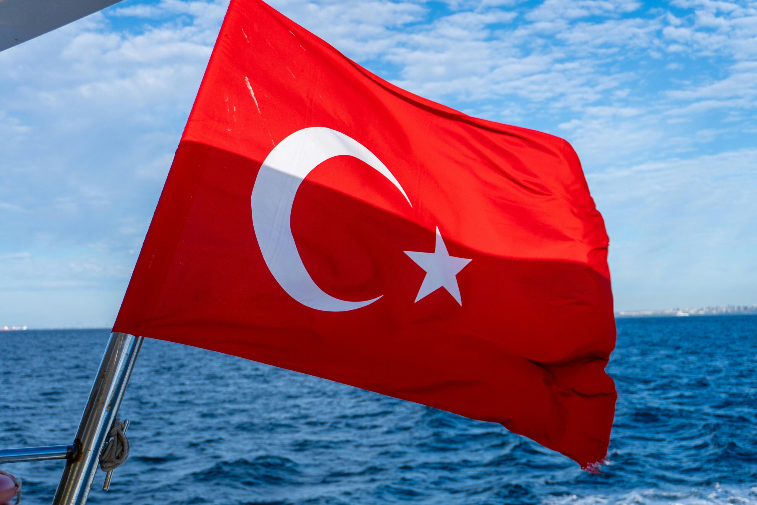 Die türkische Flagge weht an Bord eines Bootes unter einem klaren blauen Himmel und fängt einen Moment des Nationalstolzes ein.