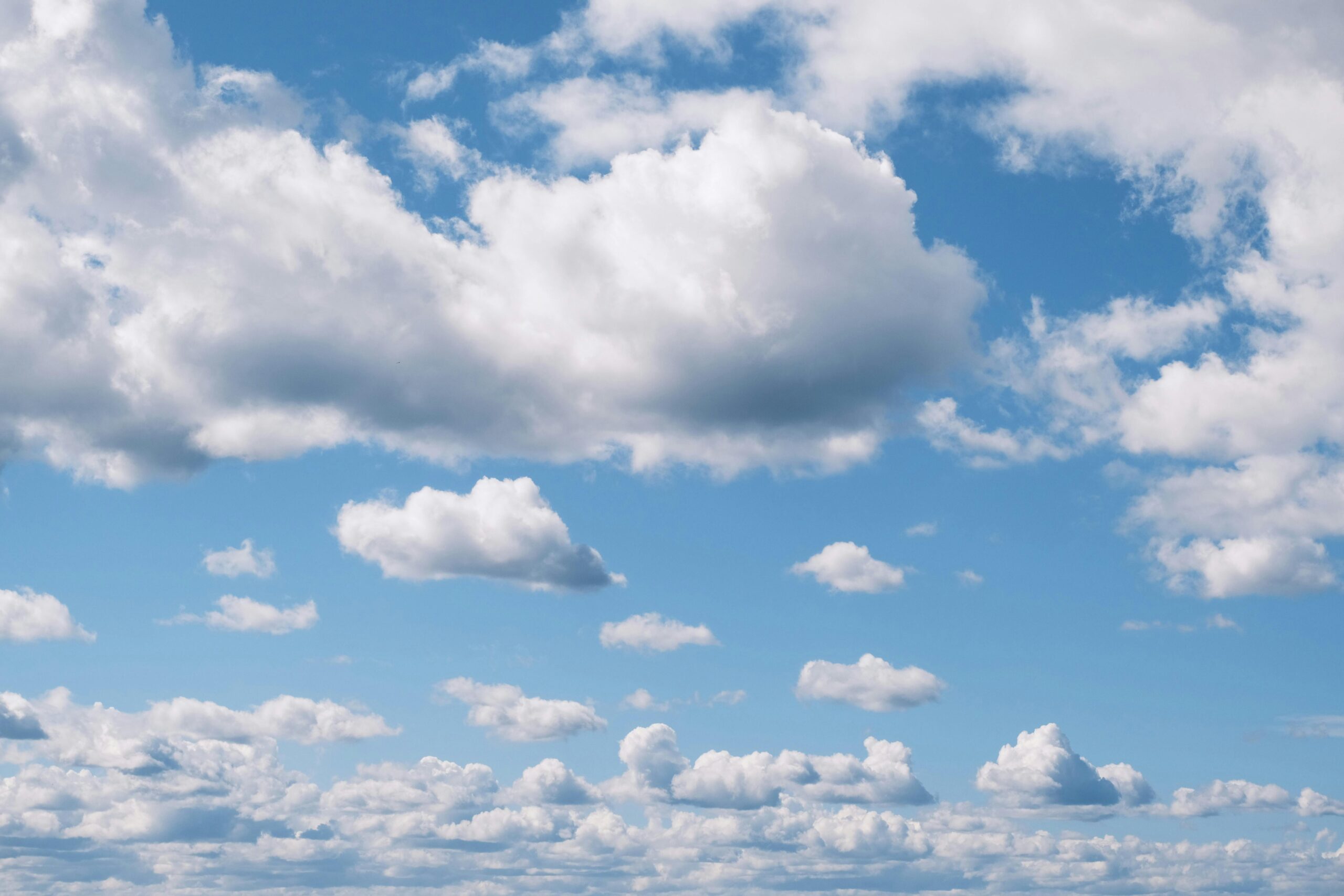 Ein ruhiger Blick auf flauschige Wolken, die über einen blauen Himmel in Marseille, Frankreich, verstreut sind.