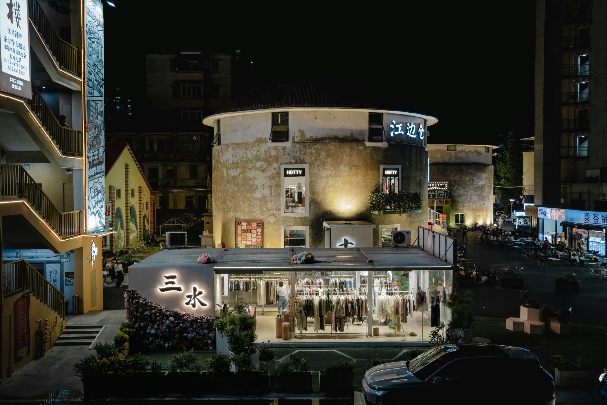 Beleuchtete Nachtansicht eines geschäftigen Einkaufsviertels in Foshan, China, mit moderner Architektur.