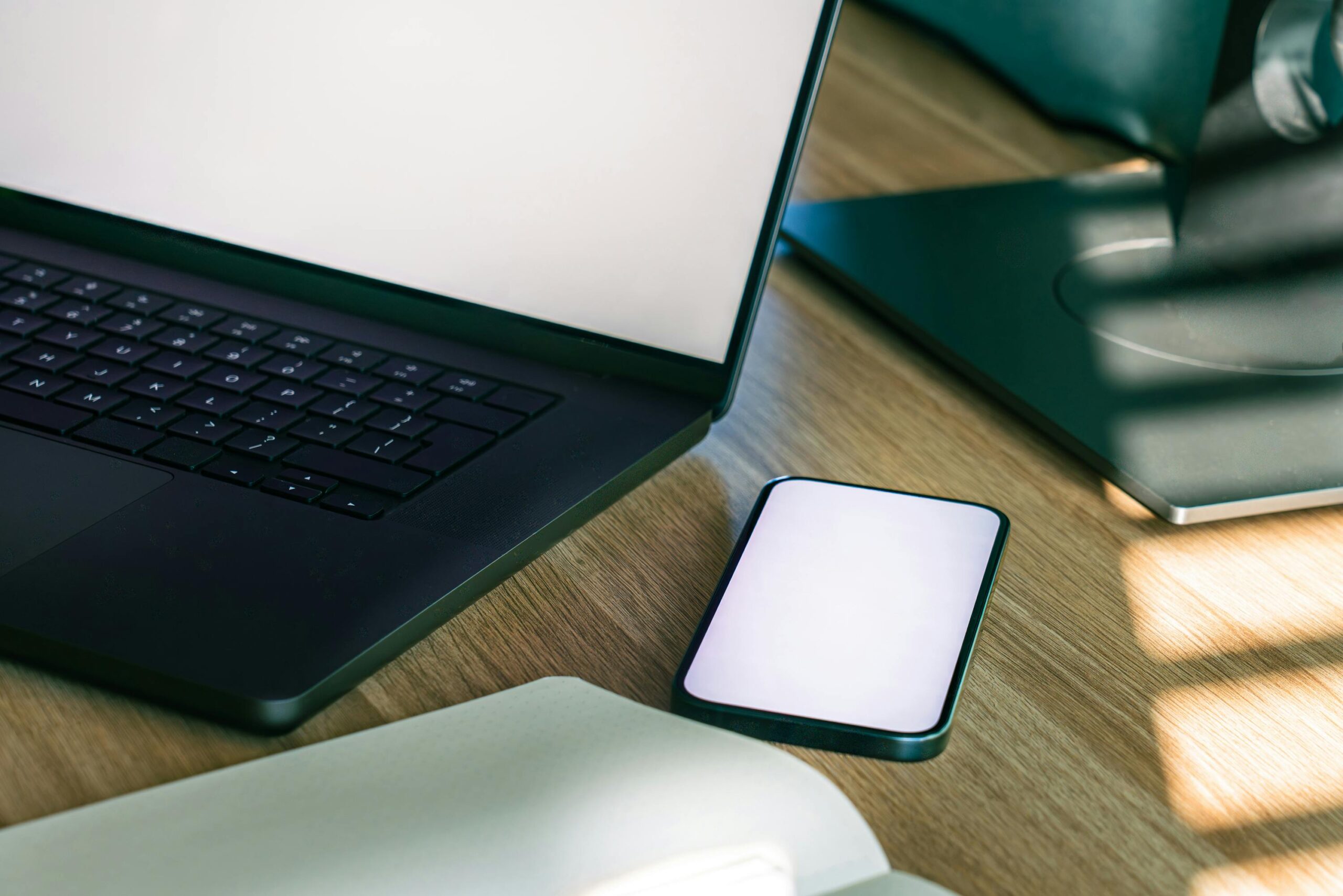 Ein eleganter Büroschreibtisch mit Laptop und Smartphone, ideal für Technik- und Geschäftsthemen.