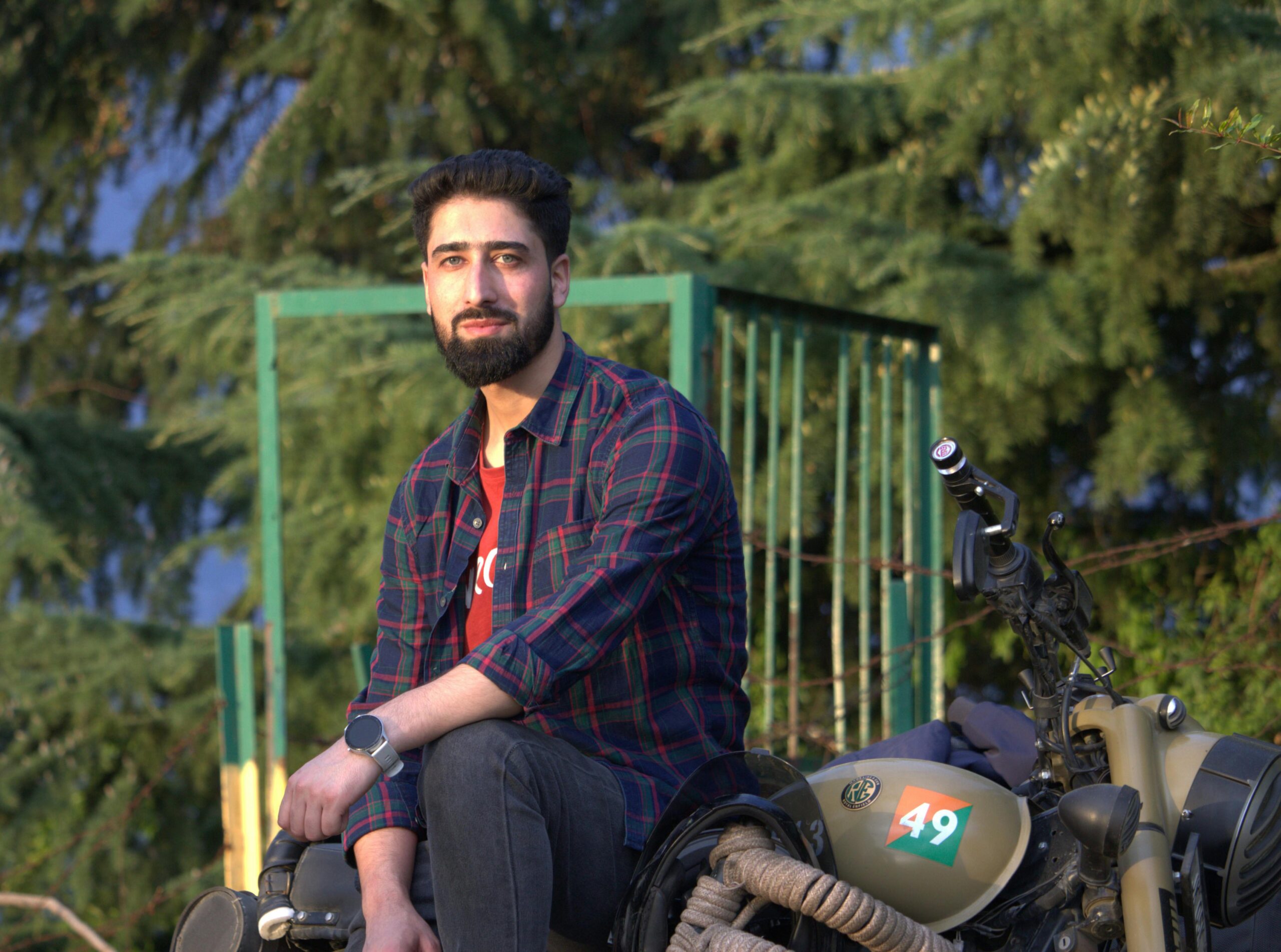 Mann sitzt im Freien in Srinagar auf einem Motorrad und zeigt Abenteuerlust.
