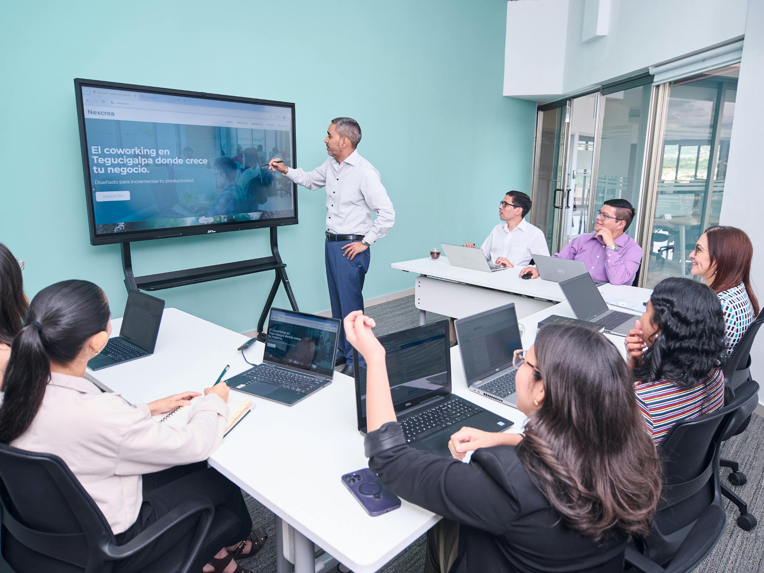 Professionelles Team führt mit Laptops und einer Projektionsleinwand eine Geschäftspräsentation durch.