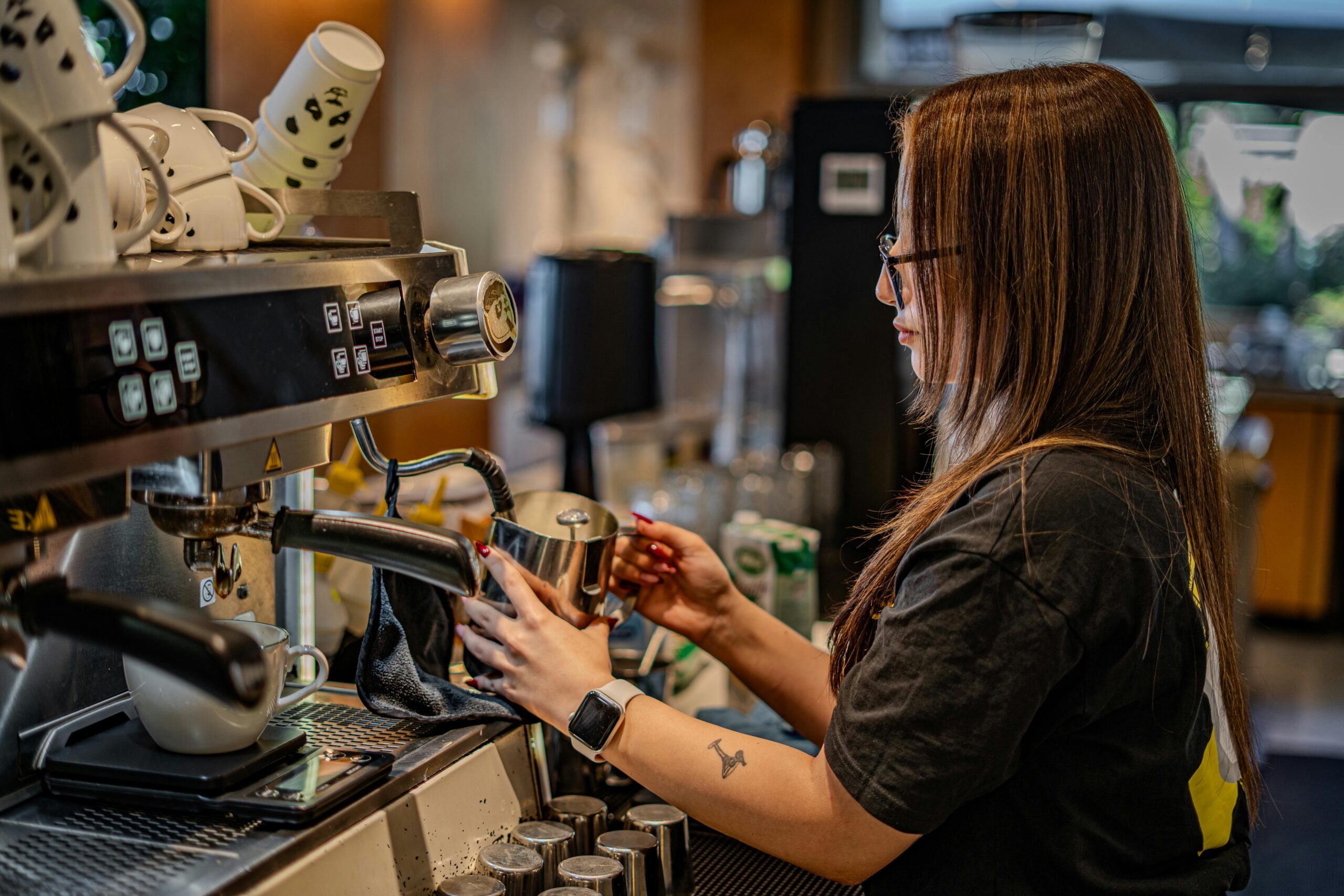 Ein Barista bereitet in einem modernen Café-Ambiente gekonnt Espresso zu.