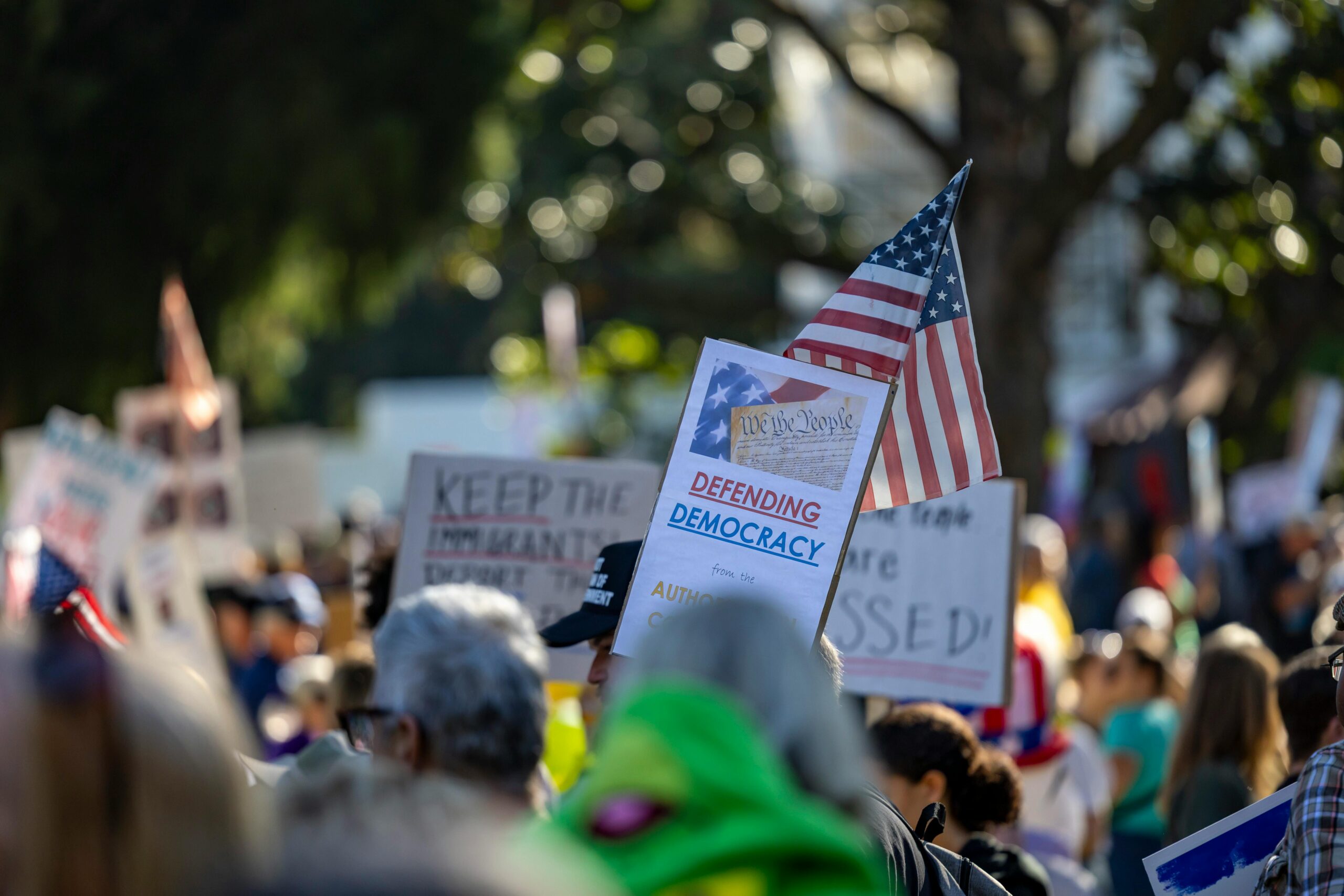 In Sacramento, Kalifornien, versammelt sich eine Menschenmenge, um mit Schildern und amerikanischen Flaggen für die Verteidigung der Demokratie zu protestieren.