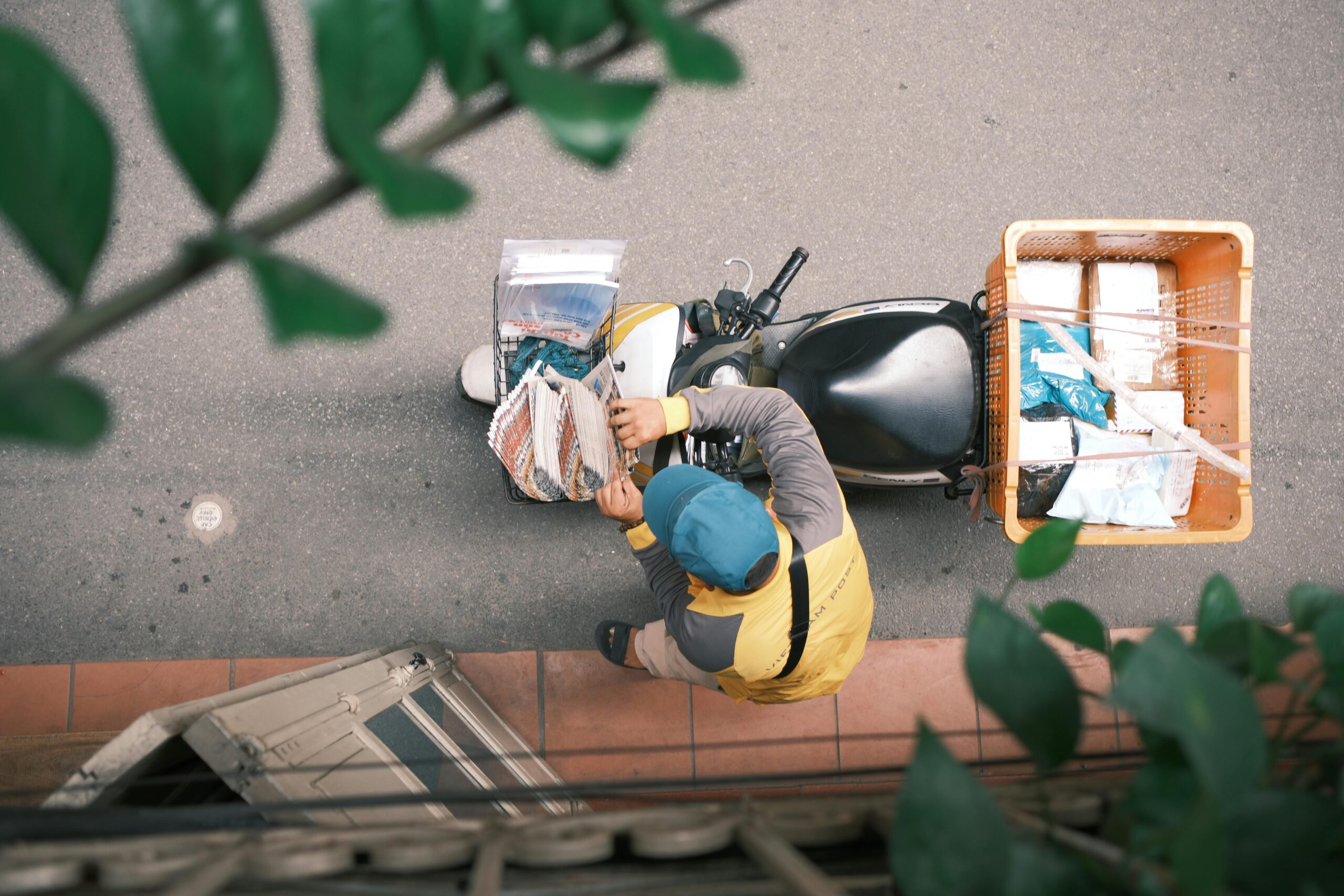 Kurier auf einem Motorrad liefert Pakete in einer belebten Straße in Hongkong aus.