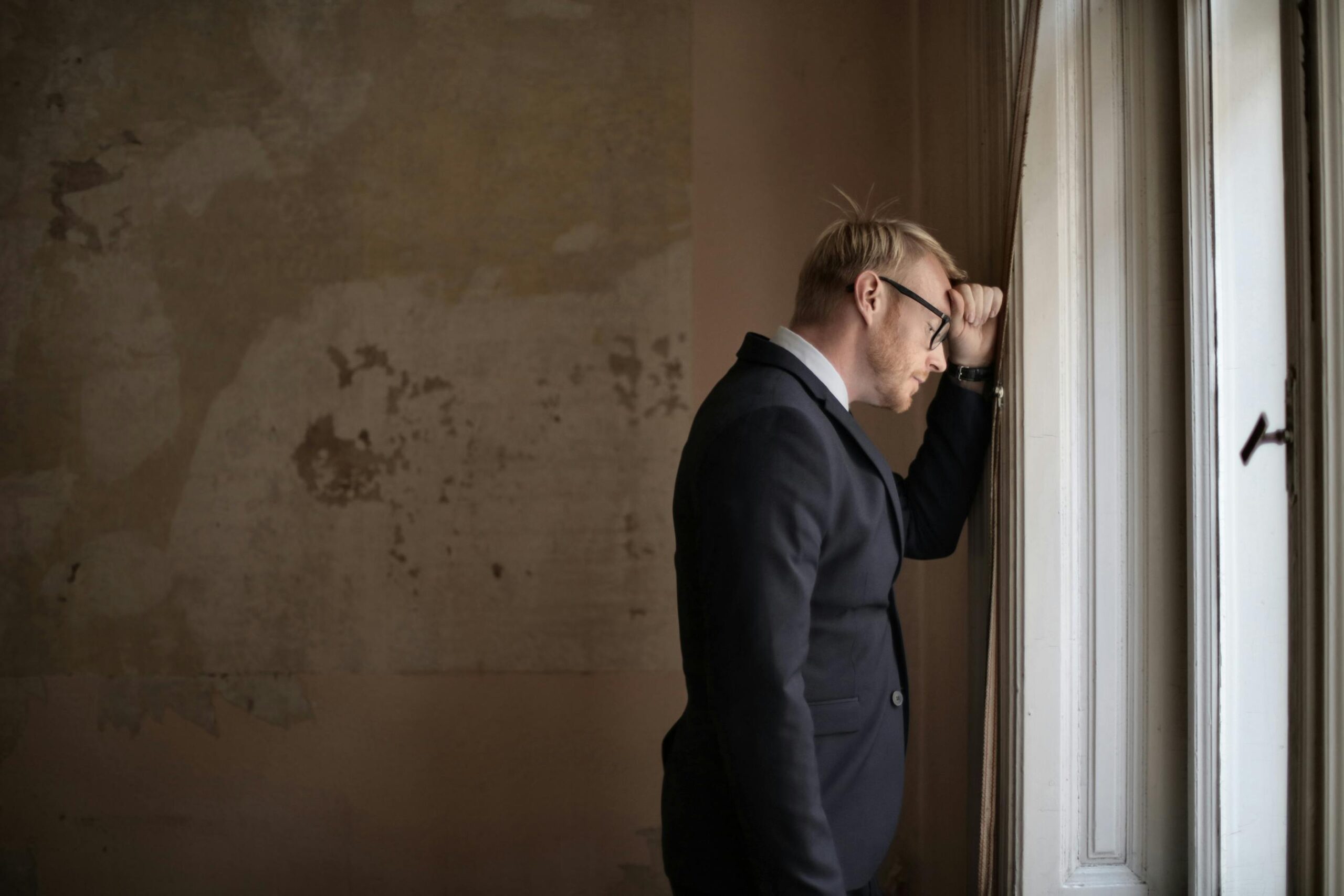 Verzweifelt Vertriebener Männlicher Unternehmer, Der Nahe Fenster Steht
